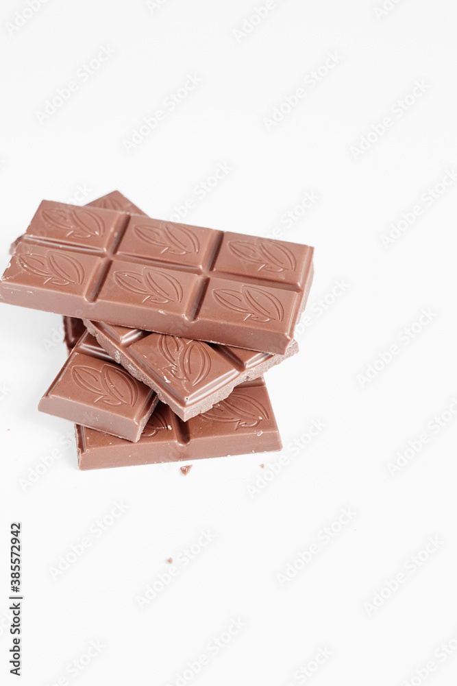 Milk chocolate pieces isolated on white background from top view, close up a chocolate bar isolated on white background Milk chocolate pieces isolated on white background from top view, close up a chocolate bar isolated on white background