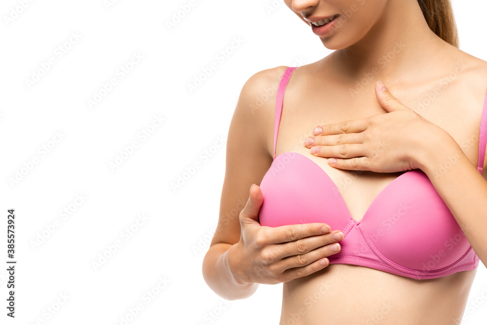 Girl wearing pink bra to examine their breasts. Stock Photo by