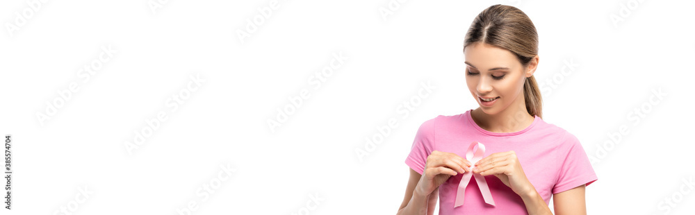 Horizontal crop of brunette woman holding pink ribbon of cancer awareness near breast isolated on white Horizontal crop of brunette woman holding pink ribbon of cancer awareness near breast isolated on white