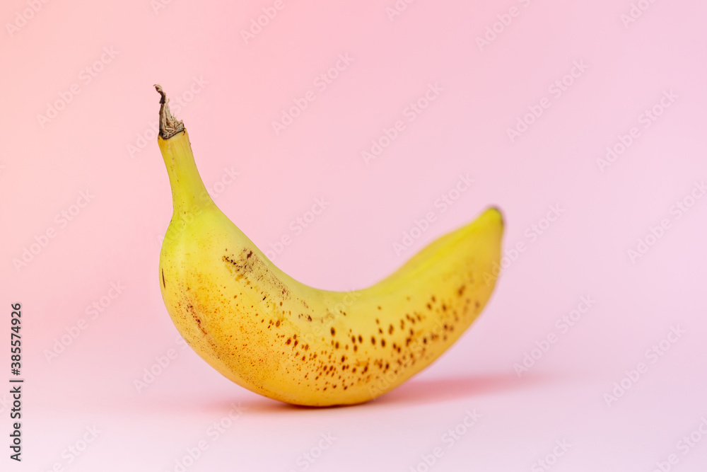 Ripe banana isolated on pastel pink background