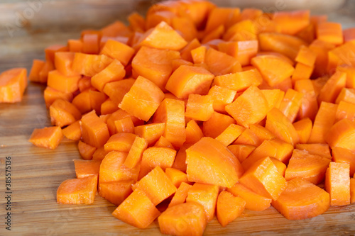 Diced carrots on wooden chopping board, food