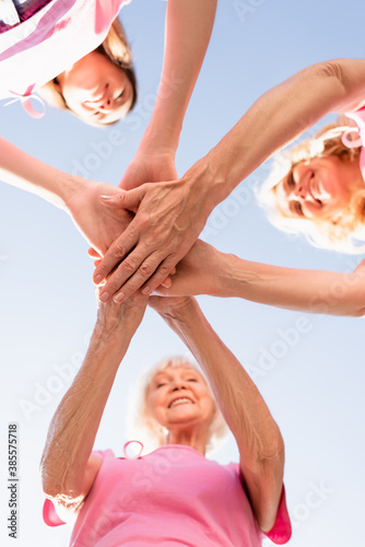 Bottom view of women's stacking hands, concept of breast cancer