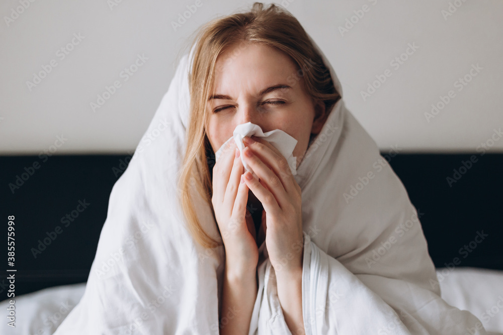 Sick woman of corona virus lying down in bed recovery from illness at home. Blowing her nose and coughing. Stay at home. Sick woman of corona virus lying down in bed recovery from illness at home. Blowing her nose and coughing. Stay at home.