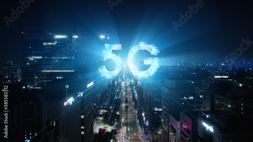 5G technology concept in the city of the future. Beautiful aerial panorama of modern skyscrapers, streets and traffic all in glittering lights on the night.  © railwayfx