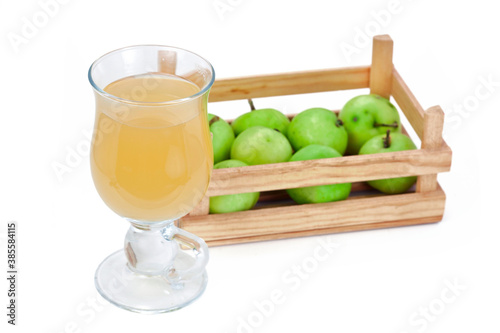 Hot apple drink in the glass mug with basket of apple fruits isolated on a white background.