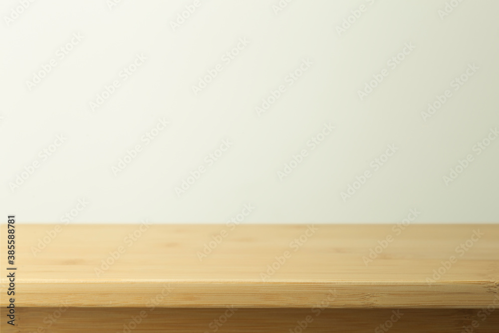 Empty wooden table with white background. Light background with a table for objects and labels. Empty wooden table with white background. Light background with a table for objects and labels.