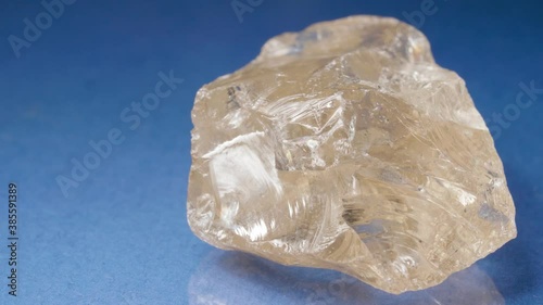 Mineral rauchtopaz close-up against a blue background. Smoky quartz. Smoky crystal. A nugget for jewelry.