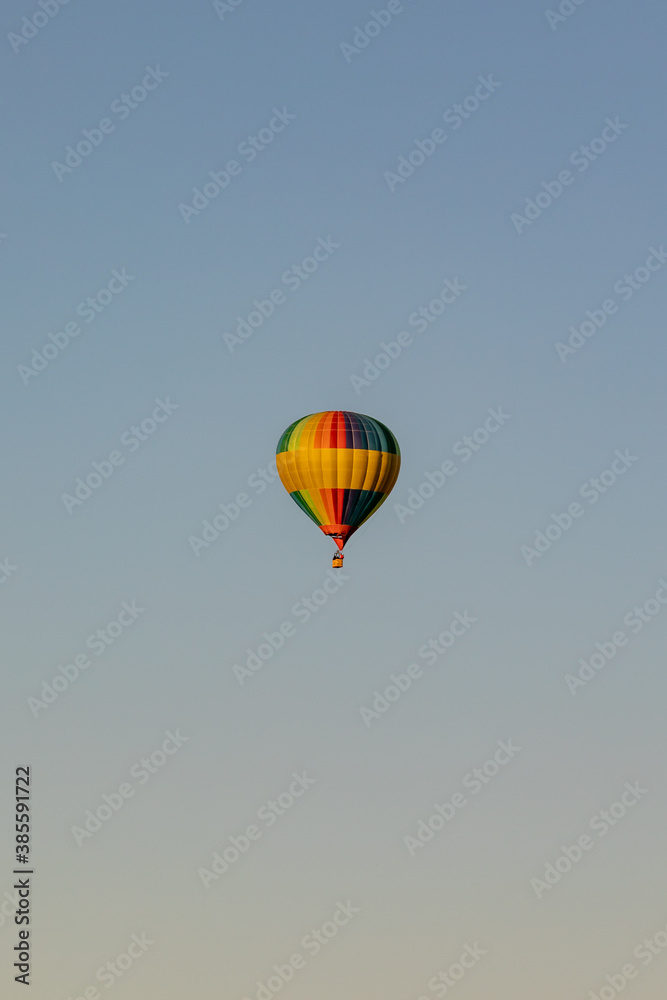 Naklejka premium Hot air balloon in the sky at sunset