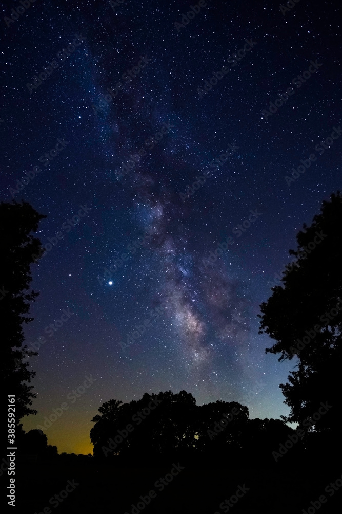 Milky Way stretching across sky over rural landscape