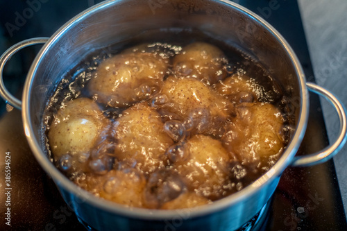 cooking potatoes in boiling water in a stainless steel pot on the stove