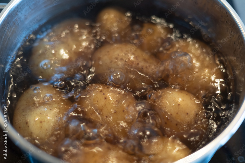cooking potatoes in boiling water in a stainless steel pot on the stove cooking potatoes in boiling water in a stainless steel pot on the stove