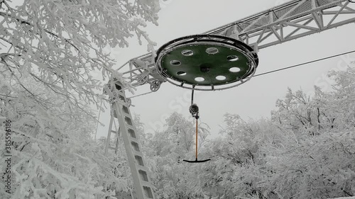 Close up shot showing T-bar lift working on the ski resort. Beautiful scenery covered with snow.