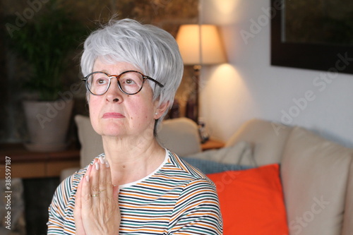 Senior woman praying with copy space 
