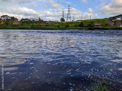 river in the background of an industrial area and blue sky with white clouds