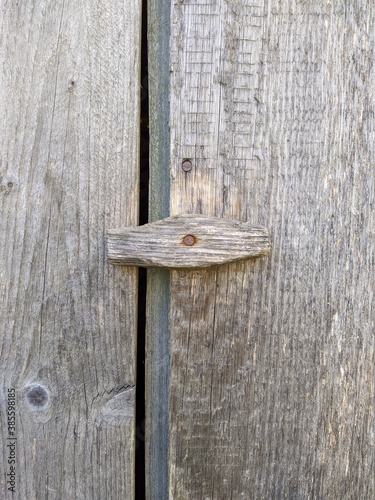 wooden and rotate gate latch on the old shabby fence