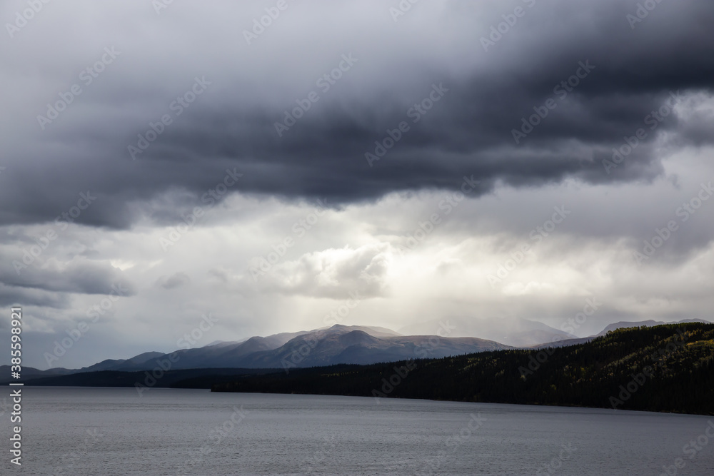 View of Scenic Lake and Mountains on a Moody Overcast Day in Canadian Nature. Taken near the Klondike Highway, Yukon, Canada.