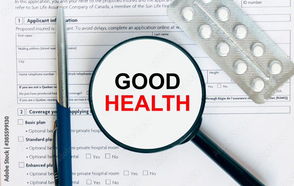 Magnifying glass with text Good Health inside lies on medical documents with pills and a blue metal pen Magnifying glass with text Good Health inside lies on medical documents with pills and a blue metal pen
