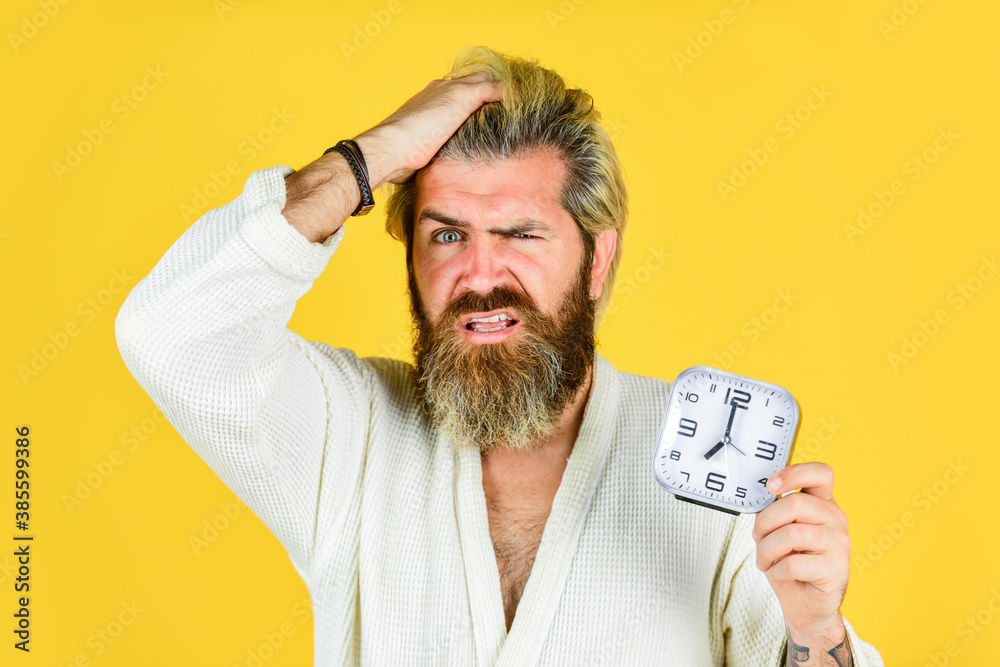 Too early. bedtime headache. Destroy the Clock. handsome angry man indoors wake up turn off the