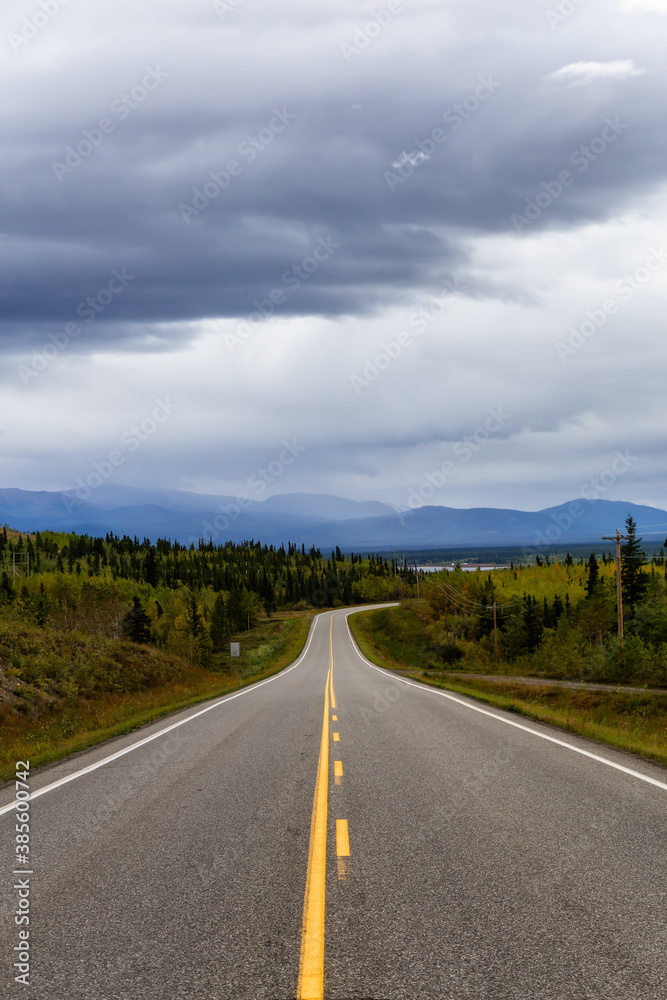 View of Scenic Road surrounded by Mountains and Trees on a Fall Day in Canadian Nature. Klondike Highway, Yukon, Canada.