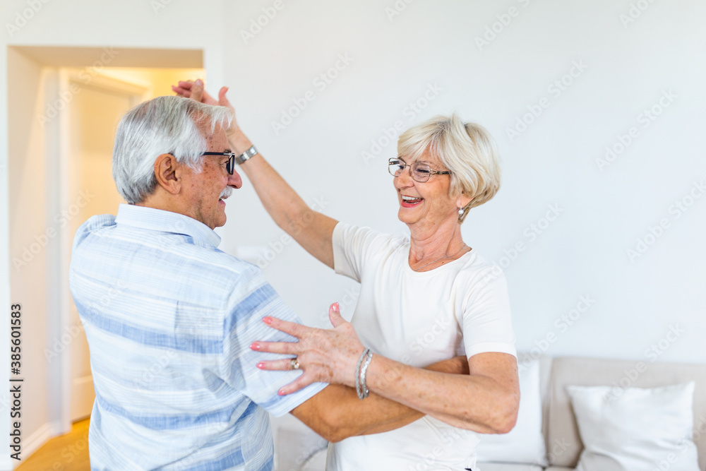 Love lives forever! Senior couple at home. Handsome old man and attractive old woman are enjoying spending time together while dancing. Love lives forever! Senior couple at home. Handsome old man and attractive old woman are enjoying spending time together while dancing.