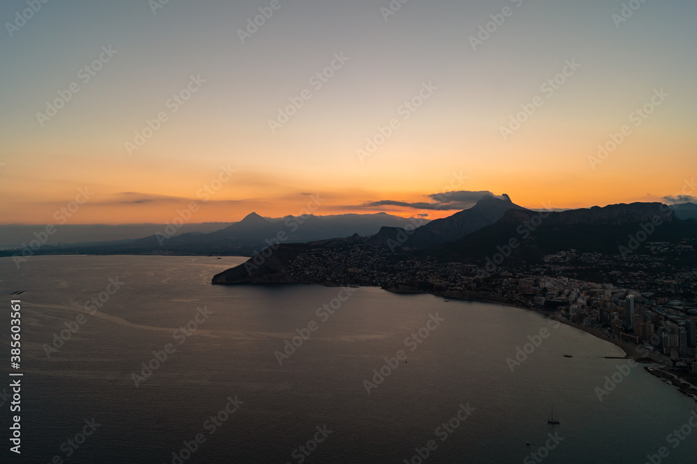Spectacular sunset with views of the city of Calpe from the Peñon d'Ifach natural park (Alicante, Spain). Photograph taken from a high altitude where you can see the beaches and houses of the city. Spectacular sunset with views of the city of Calpe from the Peñon d'Ifach natural park (Alicante, Spain). Photograph taken from a high altitude where you can see the beaches and houses of the city.