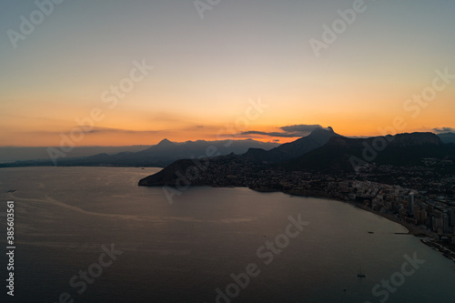 Spectacular sunset with views of the city of Calpe from the Pe  on d Ifach natural park  Alicante  Spain . Photograph taken from a high altitude where you can see the beaches and houses of the city.