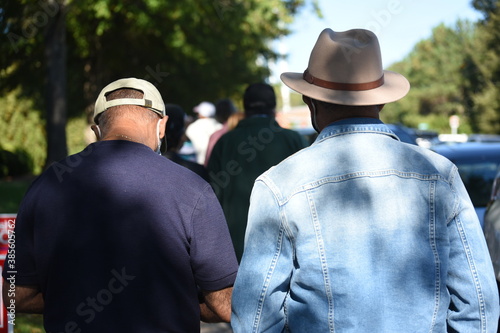 фотографія 2 African American men stand in line for the first day of early voting in North Carolina