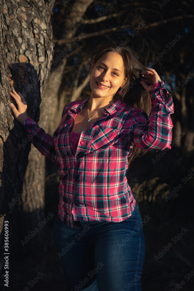 smiling young woman in plaid shirt in the field