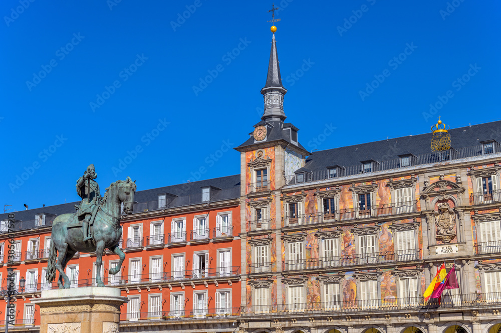 Plaza Mayor - A sunny autumn day view of the bronze equestrian statue of Philip III standing at front of one of surrounding buildings of Plaza Mayor. Madrid, Spain.