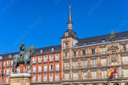 Plaza Mayor - A sunny autumn day view of the bronze equestrian statue of Philip III standing at front of one of surrounding buildings of Plaza Mayor. Madrid, Spain.