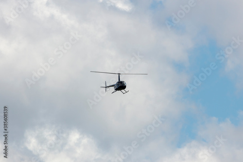 A helicopter flying in a cloudy sky in regional Australia