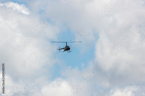 A helicopter flying in a cloudy sky in regional Australia