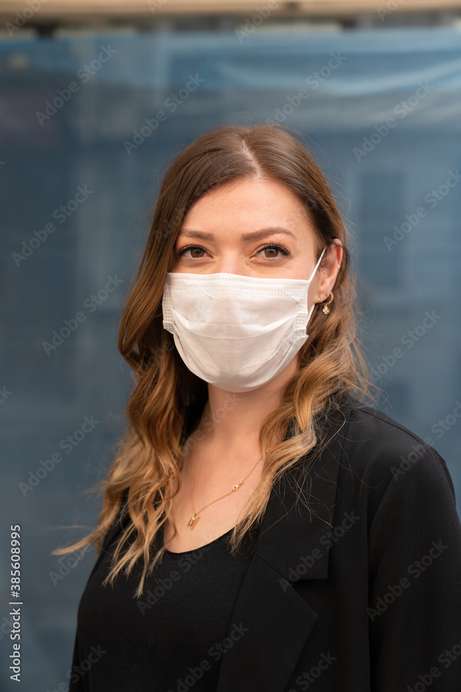 Blonde woman wearing a protective mask on the street.