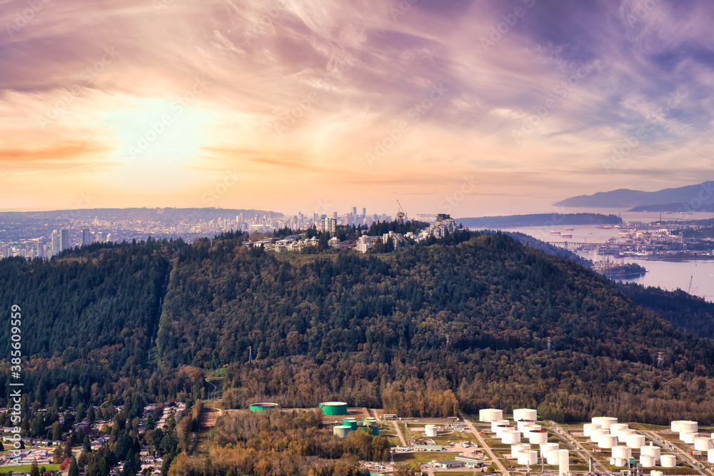 Aerial view of Burnaby Mountain during a vibrant sunset. Taken in Greater Vancouver, British Columbia, Canada. Modern City viewed from Above. Dramatic Sky Artistic Render