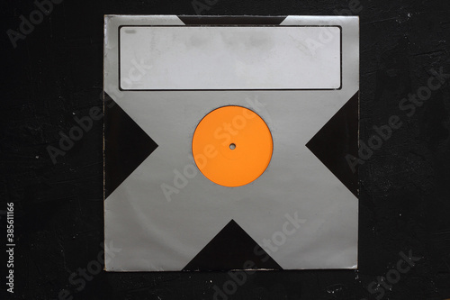 Aged black paper cover and vinyl LP record isolated on black background