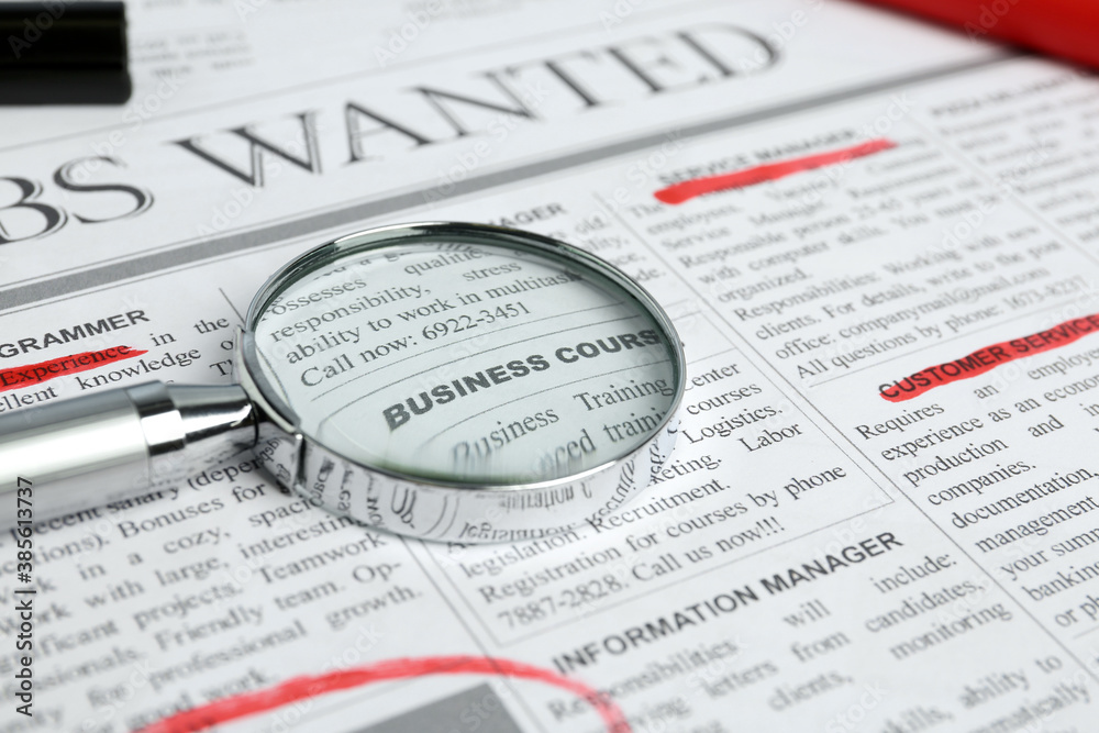 Magnifying glass and marker on newspaper. Job search concept Magnifying glass and marker on newspaper. Job search concept
