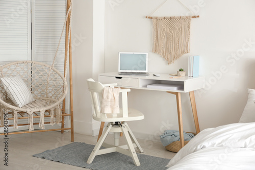 Stylish room interior with workplace and hanging chair