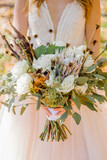 Creative bouquet of white roses in the hands of the bride close up