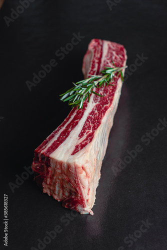 Short Rib asado de tira de res vaca carne roja en fondo negro con romero