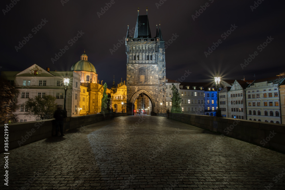 
paving blocks for sidewalks and light from street lighting on Charles Bridge from 1402 at night in the old town of Prague in the Czech Republic