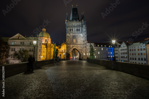  paving blocks for sidewalks and light from street lighting on Charles Bridge from 1402 at night in the old town of Prague in the Czech Republic