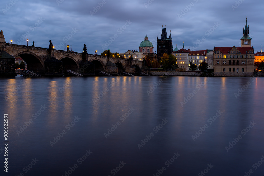 Fototapeta premium Charles Bridge. monument from 1402 in the center of prague on the flowing river vltava in the czech republic in the early evening after sunset and cloudy sky