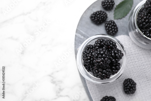 Fresh ripe blackberries on white marble table, flat lay. Space for text