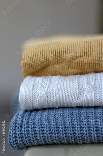 Stack of cozy sweaters. Selective focus.