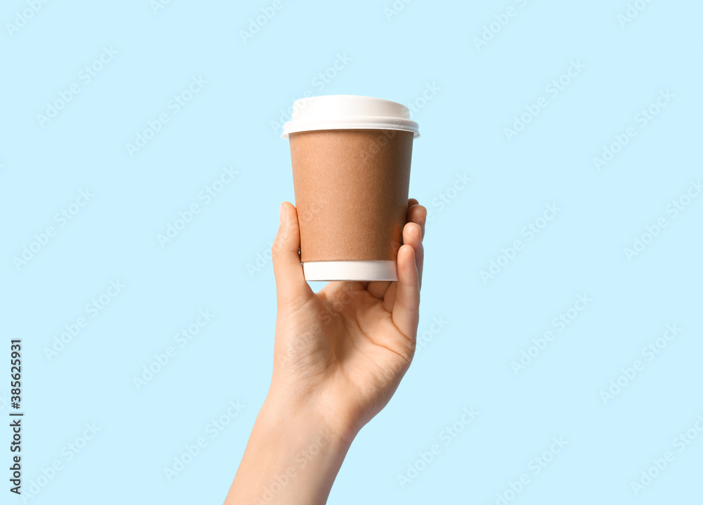 Woman holding takeaway paper coffee cup on light blue background, closeup - obrazy, fototapety, plakaty 