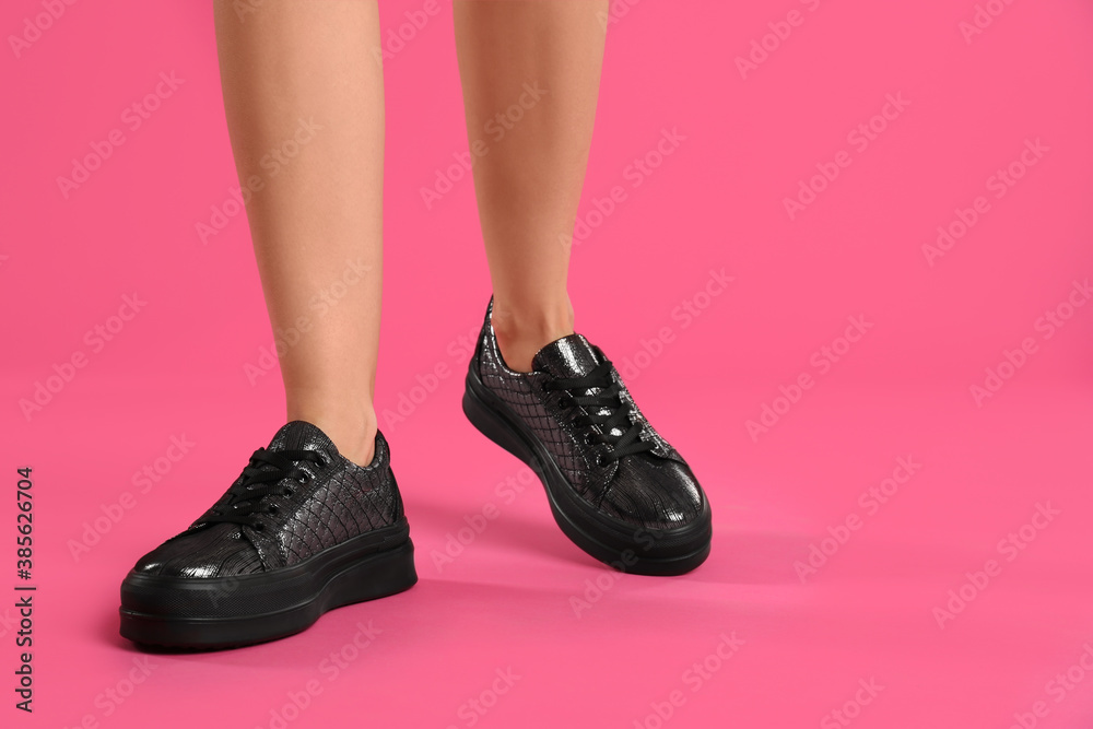 Woman wearing shoes on pink background, closeup Woman wearing shoes on pink background, closeup