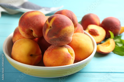 Fresh sweet peaches on turquoise wooden table  closeup