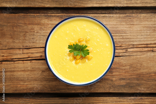 Delicious creamy corn soup on wooden table  top view