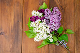 Flowering branches of lilac on wooden surface