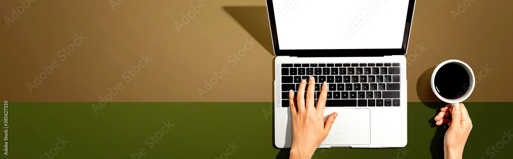 Person using a laptop computer from above Person using a laptop computer from above